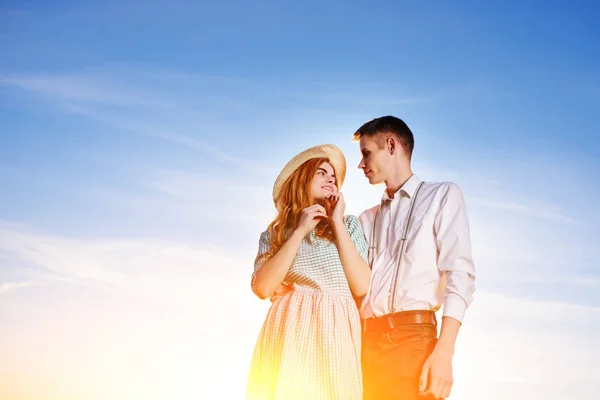 青い空を背景に立っている若いカップル — ストック写真