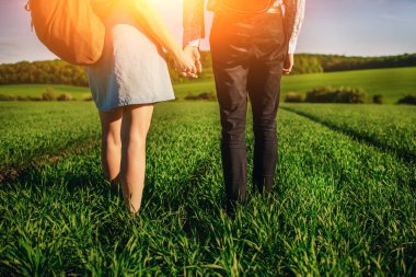 Genç çift greenfield ile geziniyor. Kadın ve erkek birbirlerini tarafından el ele tutuşarak.