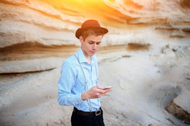 Bir akıllı telefon ekranına bir kum ocağı özgeçmişlerine bakarak çekici bir adam.