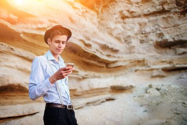Bir akıllı telefon ekranına bir kum ocağı özgeçmişlerine bakarak çekici bir adam.