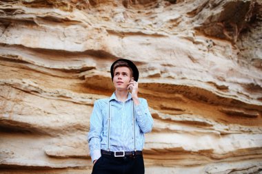 Çekici bir adam bir kum ocağı ortasında duran ve bir akıllı telefon üzerinden arama yapma.