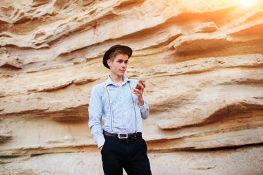 Bir akıllı telefon ekranına bir kum ocağı özgeçmişlerine bakarak çekici bir adam.