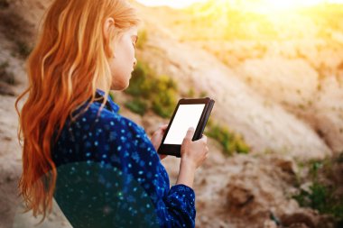 Bir tablet ekranına bir kum ocağı özgeçmişlerine bakarak kadın.