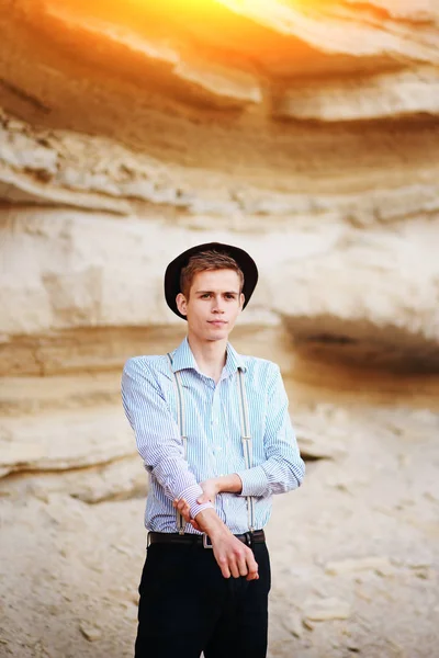 Şık çekici adam bir kum ocağı ortasında duruyor ve kameraya poz veriyor.