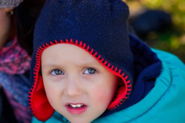 Şirin meraklı küçük çocuk bir kap içinde sarı yaprak ile kapatın. Sonbahar konsepti.