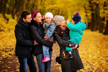 İki çocuklu aile sonbahar park kolaj içinde yürüyüş
