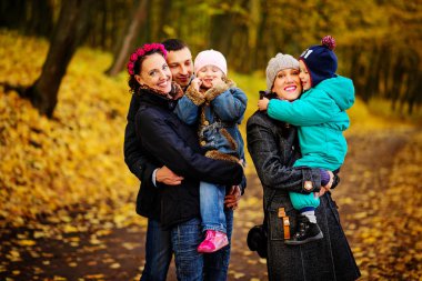 İki çocuklu aile sonbahar park kolaj içinde yürüyüş