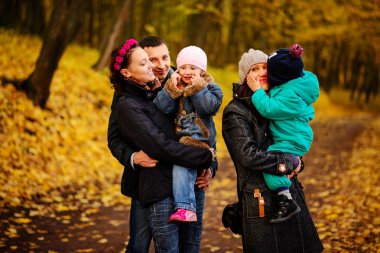 İki çocuklu aile sonbahar park kolaj içinde yürüyüş