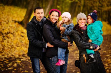 İki çocuklu aile sonbahar park kolaj içinde yürüyüş