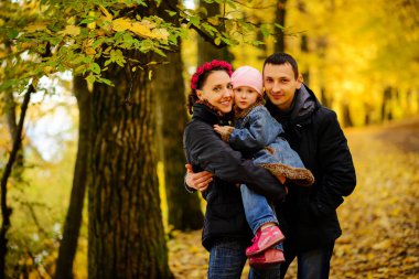 İki çocuklu aile sonbahar park kolaj içinde yürüyüş