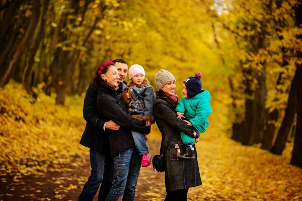 İki çocuklu aile sonbahar park kolaj içinde yürüyüş