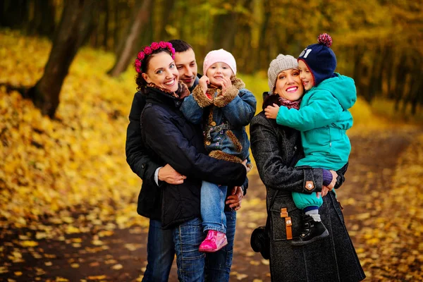 İki çocuklu aile sonbahar park kolaj içinde yürüyüş