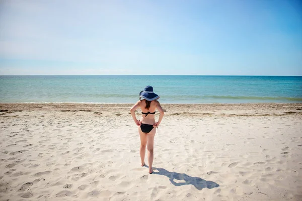 mavi şapkalı, güzel kız sahilde yürüyüş.