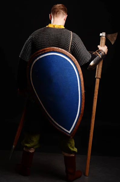 勇士站在他的背部与盾牌在他的背部和斧头在他的手中的相机 — 图库照片