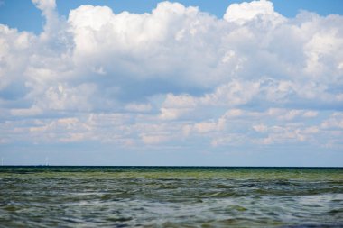 donuk bulutların üstünde güzel bir güneşli gün ile mavi okyanus.
