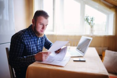 Evde biraz evrak işi yapan yakışıklı erkek.