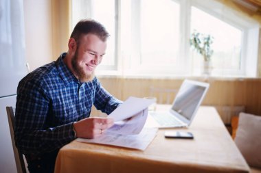 Evde biraz evrak işi yapan yakışıklı erkek.