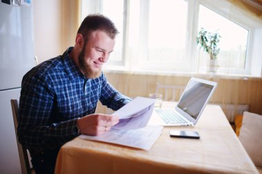 Evde biraz evrak işi yapan yakışıklı erkek.