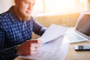 Evde biraz evrak işi yapan yakışıklı erkek.