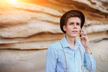 Çekici bir adam bir kum ocağı ortasında duran ve bir akıllı telefon üzerinden arama yapma.