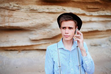 Çekici bir adam bir kum ocağı ortasında duran ve bir akıllı telefon üzerinden arama yapma.