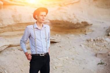 Şık çekici adam bir kum ocağı ortasında duruyor ve kameraya poz veriyor.