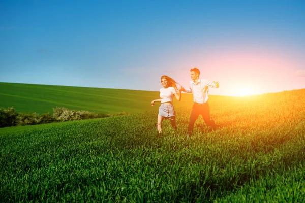 mutlu aşıklar çayır çimen yeşil ve mavi gökyüzü ile çalışan.