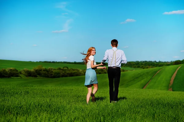 Güzel bir güneşli gün yeşil bir alana çalışan genç çift.