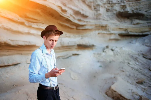 Bir akıllı telefon ekranına bir kum ocağı özgeçmişlerine bakarak çekici bir adam.