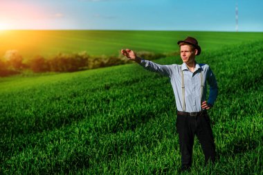 Adam sahada yandan uzun bir yere kadar içine bir şey gösterir.