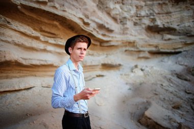 Bir akıllı telefon ekranına bir kum ocağı özgeçmişlerine bakarak çekici bir adam.