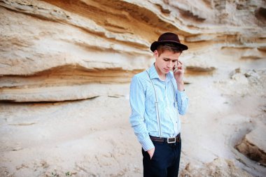 Çekici bir adam bir kum ocağı ortasında duran ve bir akıllı telefon üzerinden arama yapma.