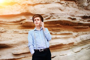 Çekici bir adam bir kum ocağı ortasında duran ve bir akıllı telefon üzerinden arama yapma.