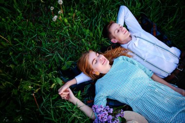 Genç çift çim üzerinde yalan ve sakin ol, yukarıdan görüntülemek.