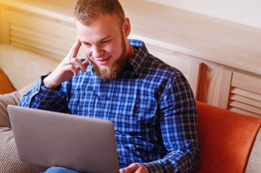 dizüstü bilgisayarınızda evde absorbe çalışan genç adam.