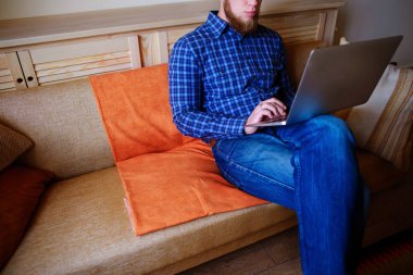 dizüstü bilgisayarınızda evde absorbe çalışan genç adam.