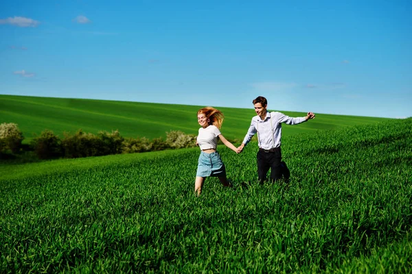 mutlu aşıklar çayır çimen yeşil ve mavi gökyüzü ile çalışan.