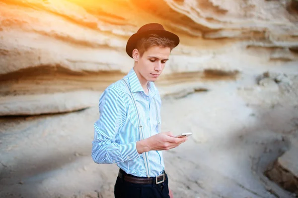 Bir akıllı telefon ekranına bir kum ocağı özgeçmişlerine bakarak çekici bir adam.