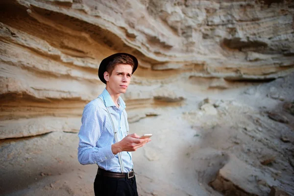 Bir akıllı telefon ekranına bir kum ocağı özgeçmişlerine bakarak çekici bir adam.