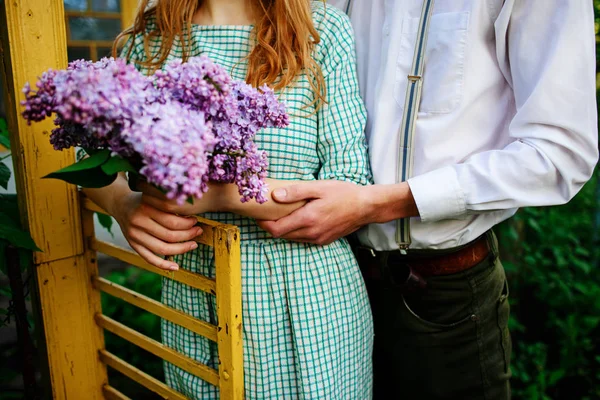 adam bir buket leylak tutan kız arkadaşı sarılma.