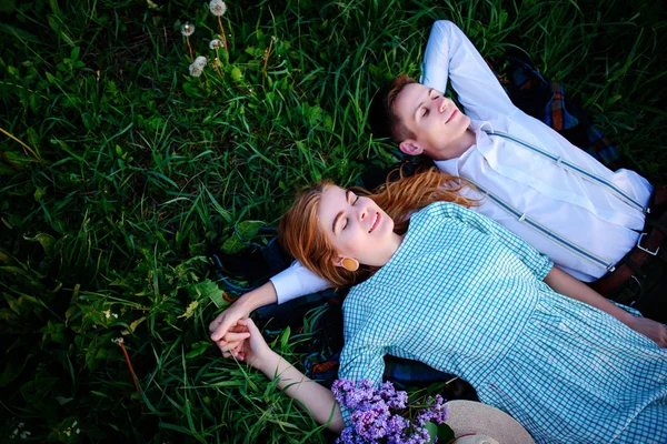 Genç çift çim üzerinde yalan ve sakin ol, yukarıdan görüntülemek.