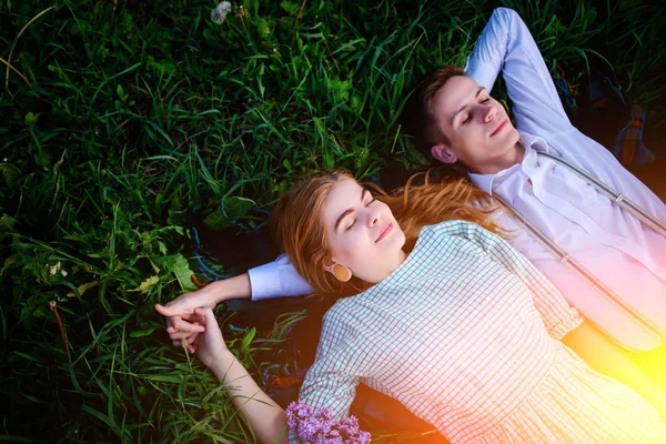 Genç çift çim üzerinde yalan ve sakin ol, yukarıdan görüntülemek.