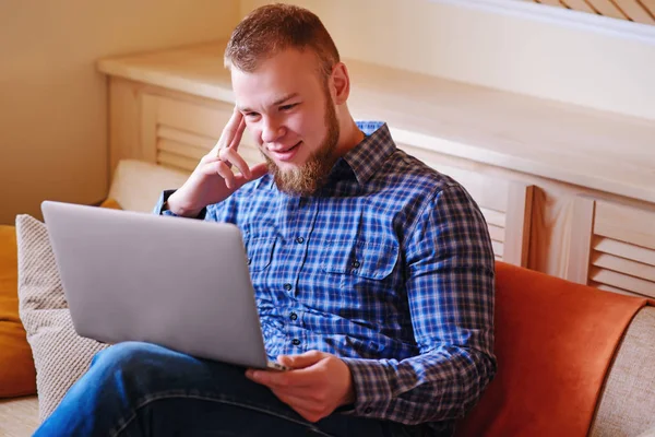 dizüstü bilgisayarınızda evde absorbe çalışan genç adam.