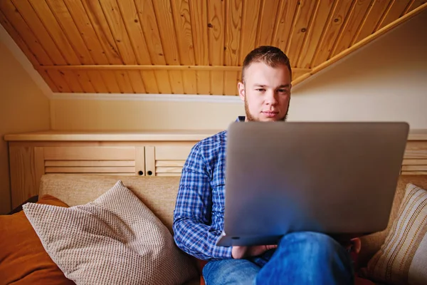 dizüstü bilgisayarınızda evde absorbe çalışan genç adam.