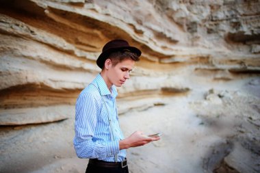 Bir akıllı telefon ekranına bir kum ocağı özgeçmişlerine bakarak çekici bir adam.