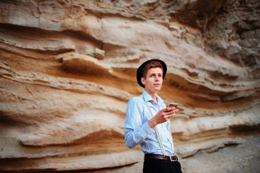 Bir akıllı telefon ekranına bir kum ocağı özgeçmişlerine bakarak çekici bir adam.