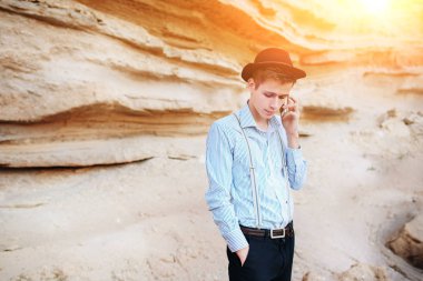 Çekici bir adam bir kum ocağı ortasında duran ve bir akıllı telefon üzerinden arama yapma.