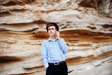 Çekici bir adam bir kum ocağı ortasında duran ve bir akıllı telefon üzerinden arama yapma.