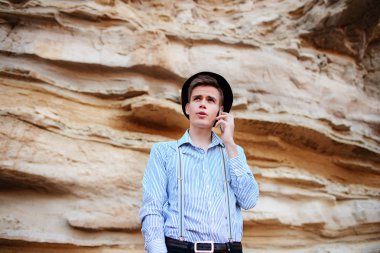 Çekici bir adam bir kum ocağı ortasında duran ve bir akıllı telefon üzerinden arama yapma.