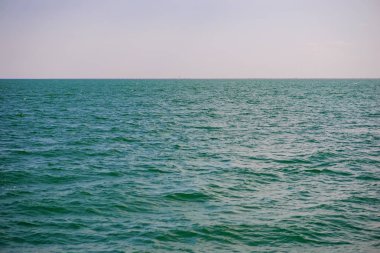 donuk bulutların üstünde güzel bir güneşli gün ile mavi okyanus.